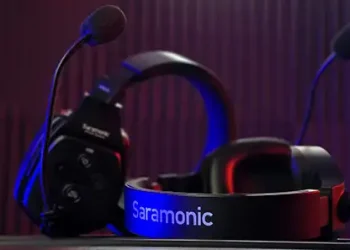 Zwei schwarze Gaming-Headsets übereinander vor violettem Hintergrund in einem dunklen Raum