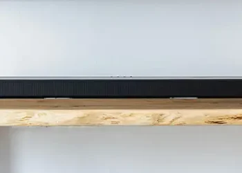 Längliche schwarze Soundbar auf einem Medienmöbel aus Eiche