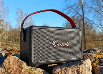 Marshall Kilburn III auf einer Steinmauer mit klarem blauem Himmel im Hintergrund