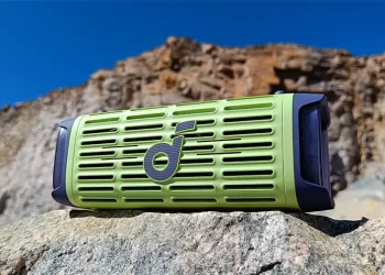 soundcore Boom 3i auf einem grauen Stein mit Bergen im Hintergrund
