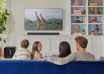 Familie sitzt vor dem Fernseher mit einem Sonos-System