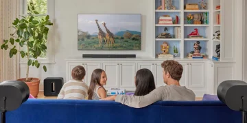 Familie sitzt vor dem Fernseher mit einem Sonos-System