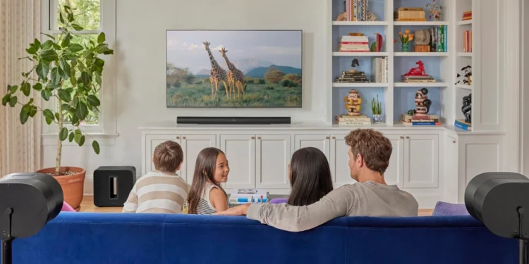 Familie sitzt vor dem Fernseher mit einem Sonos-System