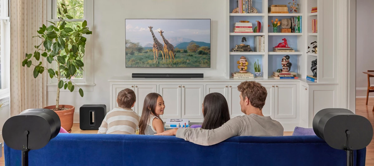 Familie sitzt vor dem Fernseher mit einem Sonos-System